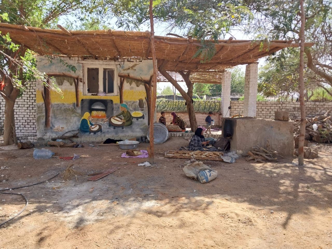 Open-air kitchen with traditional bread oven and reed roof